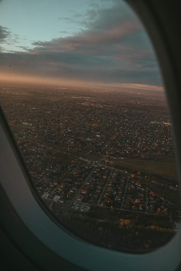 Vista de una ciudad al atardecer desde la ventanilla de un avión — Daniel Mirabal